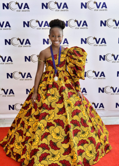 Ava Augustin at the NOVA Star Awards red carpet in an African inspired dress with a medal - Credit: Candace Wood Photography
